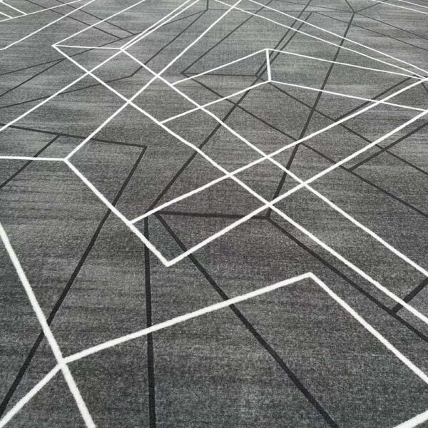 Custom printed nylon rug in grey with white and black intersecting geometric line pattern creating angular shapes