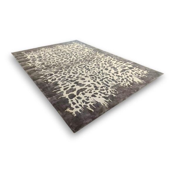 Custom hand-tufted rectangular bamboo silk rug with abstract leopard print pattern in cream and beige on dark brown background