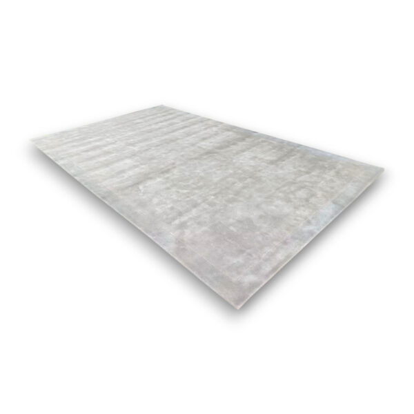 Custom hand-tufted rectangular rayon rug in light gray with subtle textured pattern and visible border