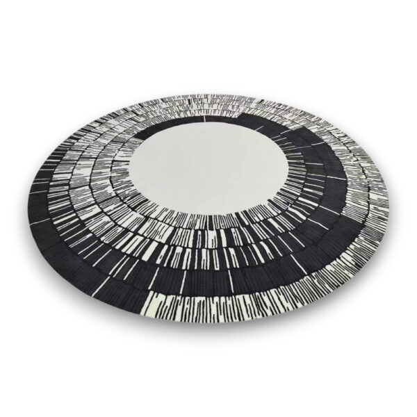 Custom printed round nylon rug with cream center and black radiating pattern creating sunburst design with varied line lengths