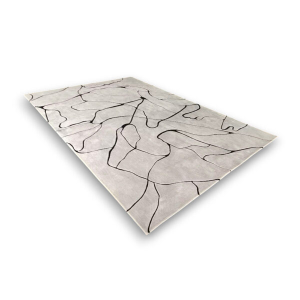 Custom hand-tufted rectangular acrylic rug with black line drawing pattern on cream background resembling puzzle pieces