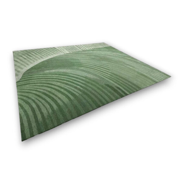 Custom hand-tufted rectangular rug in green with curved linear pattern creating flowing directional movement