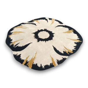 Custom hand-tufted flower-shaped wool rug in cream with black center and gold accent details resembling a large daisy bloom