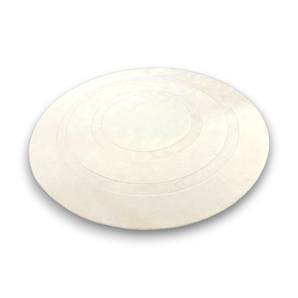 Custom hand-tufted round wool rug in white with subtle concentric circle pattern in varying pile heights