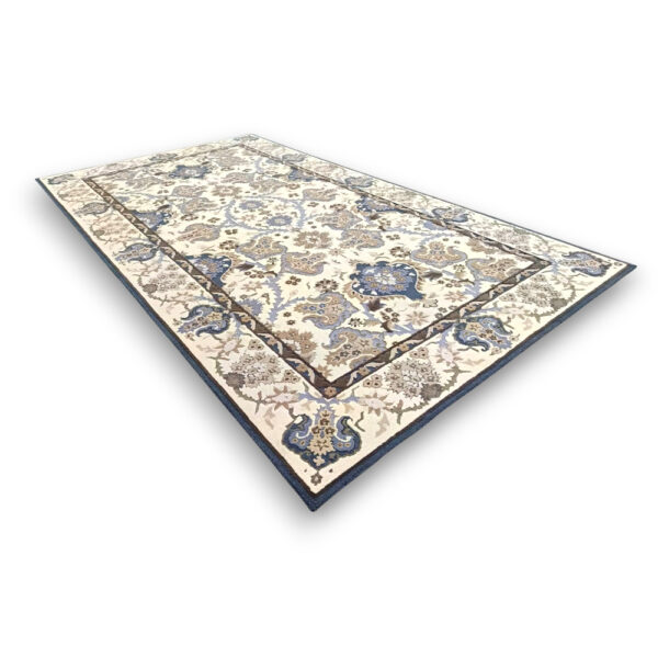 Custom tufted vintage wool rug in cream with traditional Persian-style all-over pattern featuring blue paisley motifs