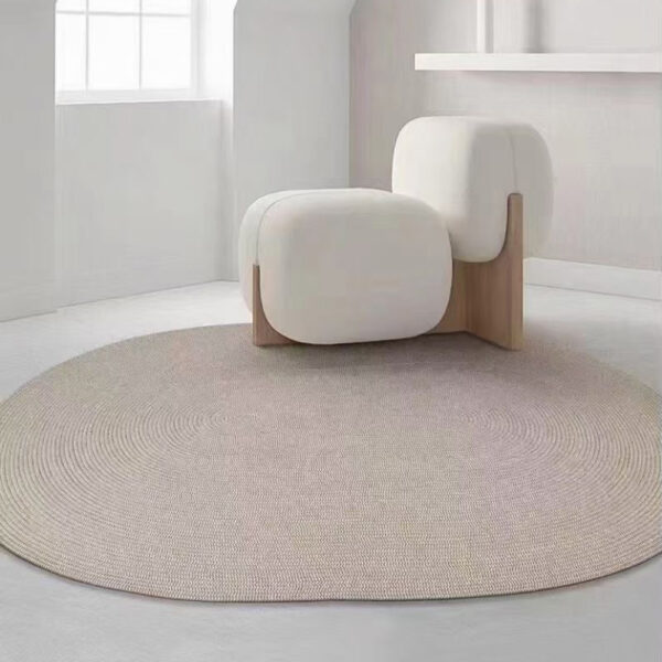 Custom woven gluefree round wool rug in neutral beige with concentric circle pattern placed in minimalist living room