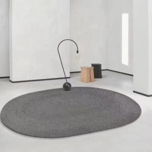Custom woven gluefree oval wool rug in charcoal grey with concentric pattern placed in modern minimalist room