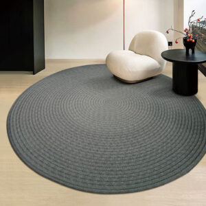 Custom woven gluefree round wool rug in charcoal grey with concentric circle pattern placed in modern living room